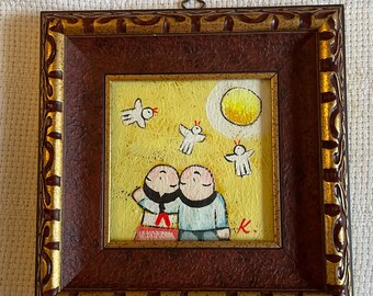 Può includere: Dipinto incorniciato con due figure su sfondo giallo, con un sole e figure di uccelli bianchi. L'opera è in una cornice ornata marrone e oro. Il dipinto ha uno stile folk art.