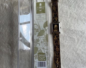 Può includere: Un orologio da polso rettangolare con cinturino nero caratterizzato da un motivo a foglie dorate e un ritratto della regina Elisabetta I sul quadrante. L'orologio è accanto alla sua custodia in plastica trasparente, che include una scheda con il logo della National Portrait Gallery, il testo Queen Elizabeth I, Oil on panel, By Nicholas Hilliard, c.1575, NPG 190 e un codice a barre.