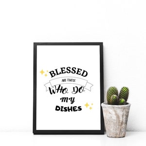 Puede incluir: Impresión enmarcada en negro con el texto "Blessed are those who do my dishes" en blanco con estrellas doradas sobre un fondo blanco.
