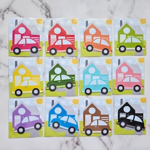 May include: Twelve colorful house and car illustrations. Each illustration features a house with a chimney and a car in front of it. The houses are in different colors, including red, yellow, green, blue, pink, purple, brown, and black. The cars are in the same colors as the houses.