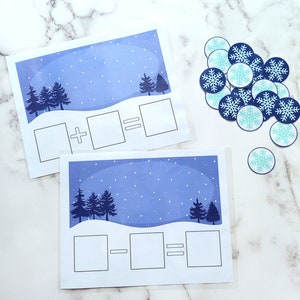 May include: Two printable winter-themed maths worksheets with blue backgrounds and white snowflakes. The first worksheet has a plus sign and the second worksheet has a minus sign. Both worksheets have spaces for numbers and an equals sign.