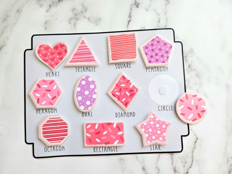 Pode incluir: Um quadro branco com formas rosa e vermelhas com nomes por baixo. As formas incluem um cora&ccedil;&atilde;o, um tri&acirc;ngulo, um quadrado, um pent&aacute;gono, um hex&aacute;gono, um oval, um diamante, um c&iacute;rculo, um oct&oacute;gono, um ret&acirc;ngulo e uma estrela.