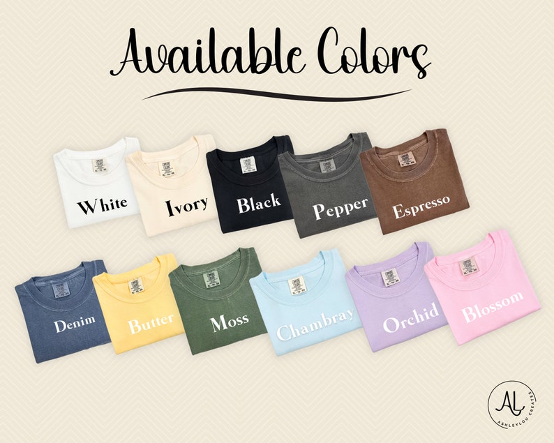 May include: A selection of t-shirts in various colours, including white, ivory, black, pepper, espresso, denim, butter, moss, Chambray, orchid, and blossom. The shirts are folded and arranged in a row, with the colour names printed below each shirt.