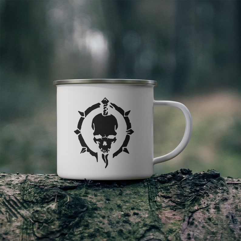 May include: White enamel camping mug with a black skull and dagger design inside a circle of thorns.