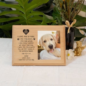 May include: A wooden photo frame with a picture of a golden retriever puppy. The frame has an engraved message that reads "I love you so mush. I miss your kisses. I miss our walks. I miss every moment we spent together. I will miss you always till we meet again at the rainbow bridge. Lucky 2009-2023 Sweetest little girl."