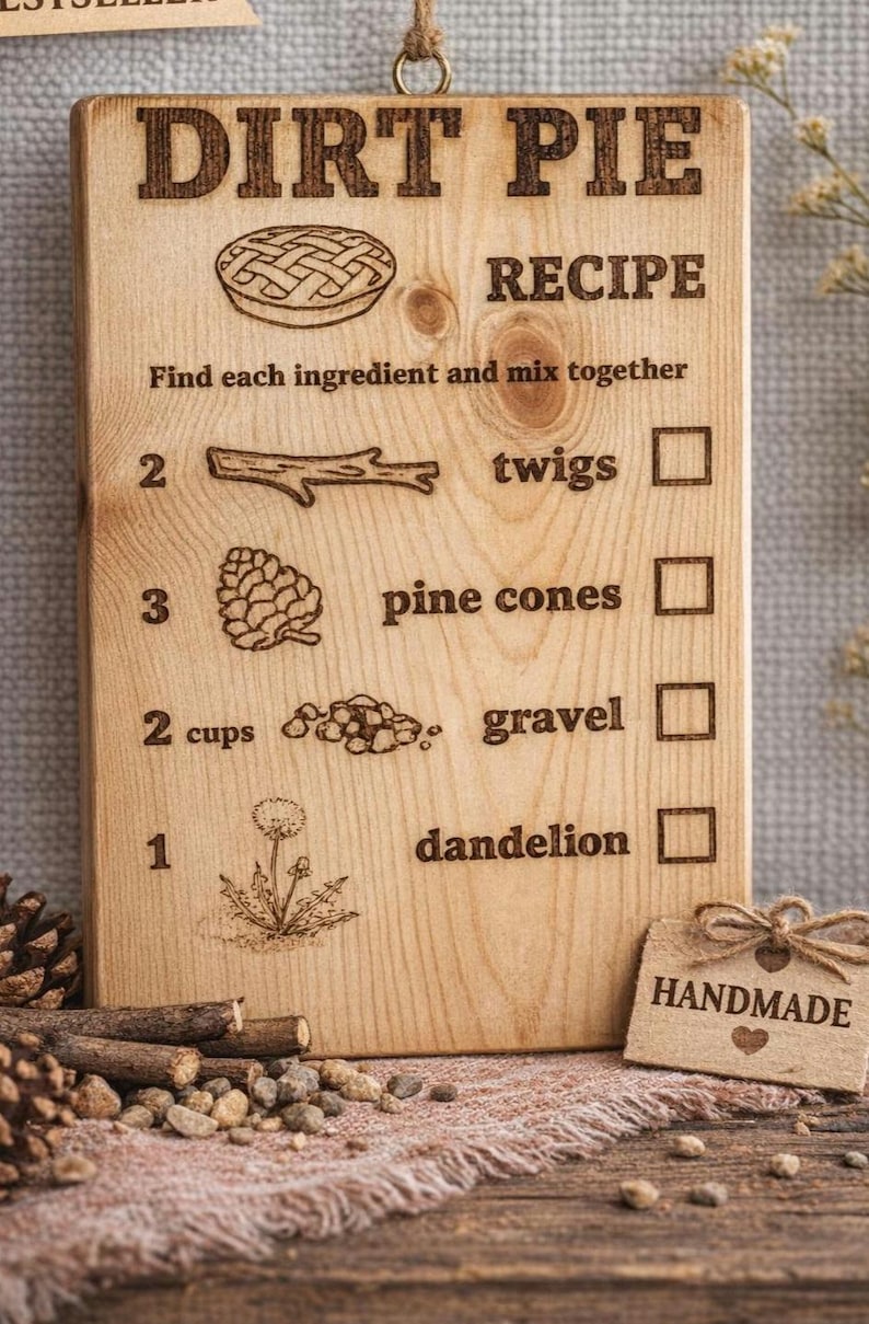 Pu&ograve; includere: Targa in legno con la scritta "DIRT PIE RECIPE" incisa in alto. La ricetta comprende rametti, pigne, ghiaia e dente di leone. &Egrave; attaccata una piccola etichetta con la scritta "HANDMADE".