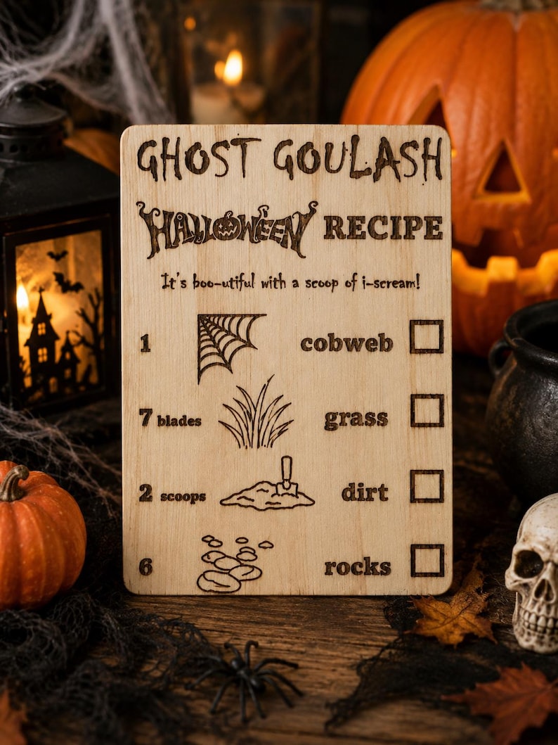 Pu&ograve; includere: Un cartello di ricetta di Halloween in legno con la scritta "Ghost Goulash Halloween Recipe". Il cartello include illustrazioni di una ragnatela, erba, terra e rocce. Sono visibili anche una piccola zucca, un teschio e un ragno.