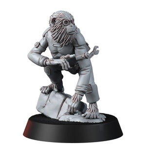 Puede incluir: Figura gris de una criatura simiesca con mono, agachada sobre una roca. La figura tiene gafas, una llave inglesa y una textura detallada similar a la piel. Montada sobre una base negra, adecuada para juegos de mesa o exhibición.