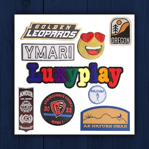 May include: Assortment of embroidered patches featuring various designs, including a smiling face with heart-shaped sunglasses, a mountain range with a crescent moon, a cobra with the text "Strikeforce Cobra 20 22 Alpha 1", and the text "Golden Leopards", "Ymari", "Luxyplay", "Amour Est. 2020", "Holdtight", and "Oregon".