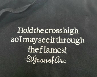Joan of Arc, Hold the cross high so I can see it through the flames! quote embroidered on an apron