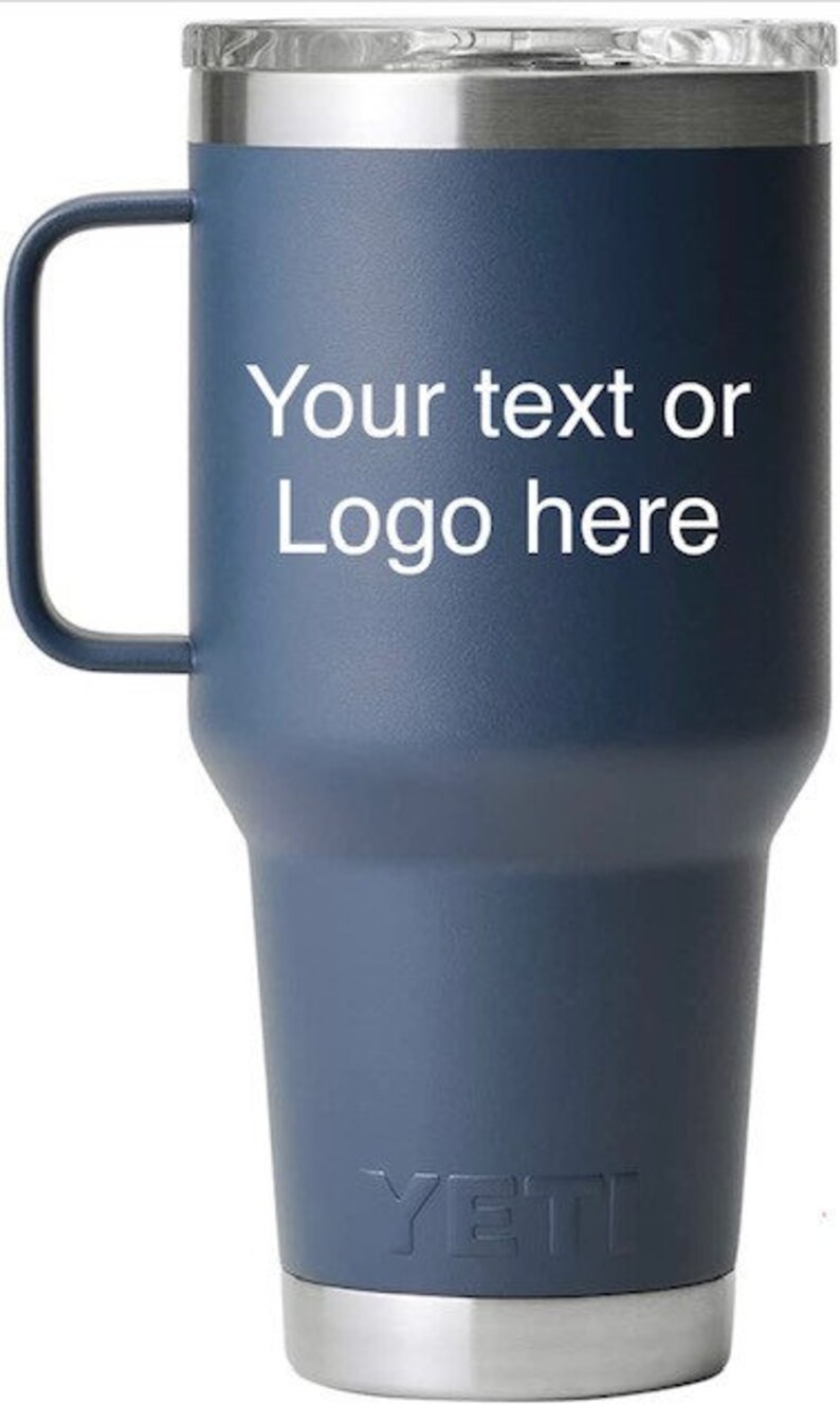 Puede incluir: Un vaso Yeti azul con asa y tapa de acero inoxidable. El vaso tiene el texto "Your text or Logo here" impreso en el lateral.