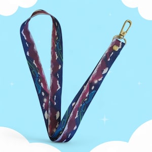 May include: A purple, blue, and green patterned lanyard with a gold metal clip. The lanyard has a design of clouds and mountains.