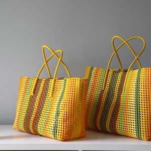 May include: Two yellow, green, orange, and red striped woven tote bags with yellow handles.