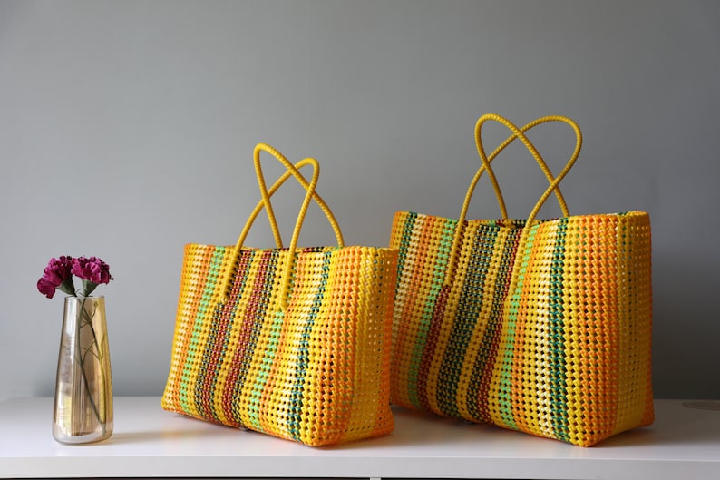 May include: Two yellow, green, orange, and red striped woven tote bags with yellow handles.