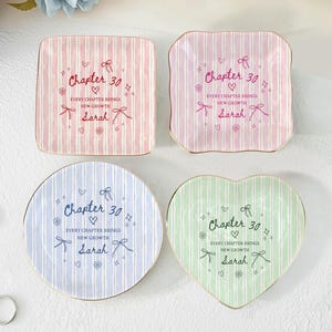 May include: A set of three ceramic mugs with a speckled, matte finish. Each mug features a different color: light blue, cream, and gray. The mugs have a simple, modern design with a rounded shape and a comfortable handle.