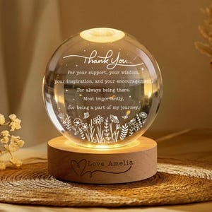 May include: A spherical glass night light featuring the engraved text Thank You for your support, your wisdom, your inspiration, and your encouragement. For always being there. Most importantly, for being a part of my journey. The base is wood with Love Amelia.