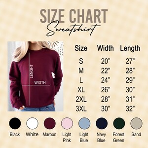 Peut inclure: Tableau des tailles pour un sweat-shirt avec des mesures en pouces. Le tableau indique la largeur et la longueur du sweat-shirt dans les tailles S, M, L, XL, 2XL et 3XL. Le tableau est affich&eacute; sur un fond beige avec un sweat-shirt marron dans le coin sup&eacute;rieur gauche.