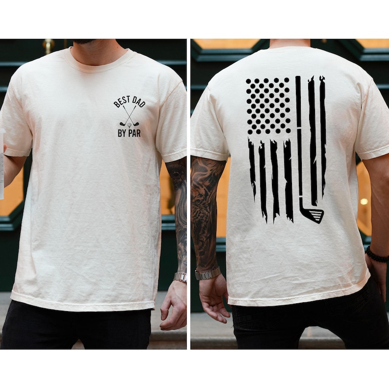 Peut inclure: Un t-shirt blanc avec un motif noir sur le devant qui dit "Best Dad By Par" avec deux clubs de golf crois&eacute;s. Le dos du t-shirt pr&eacute;sente un motif noir d'un club de golf et de balles de golf en forme de drapeau am&eacute;ricain.