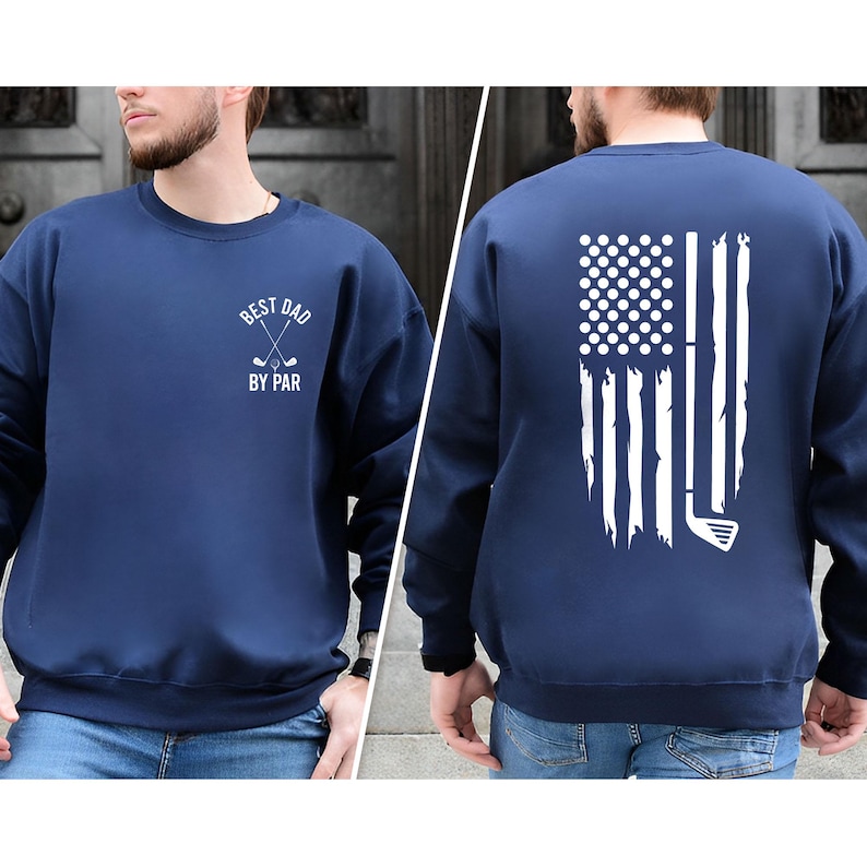Peut inclure: Un sweat-shirt bleu marine avec un motif blanc sur le devant qui dit "Best Dad By Par" avec des clubs de golf crois&eacute;s. Le dos du sweat-shirt pr&eacute;sente un motif blanc d'un drapeau am&eacute;ricain d&eacute;labr&eacute; avec un club de golf.