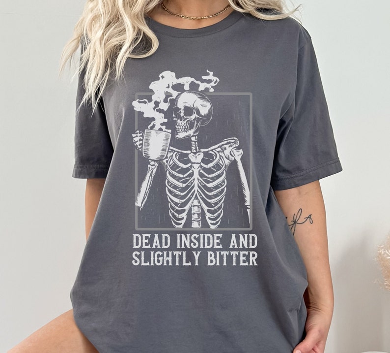 May include: A gray t-shirt with a skeleton holding a cup of coffee and the text "Dead inside and slightly bitter".