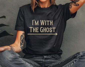 May include: A black t-shirt with the text "I'm with the Ghost" printed in beige with an arrow pointing to the right.