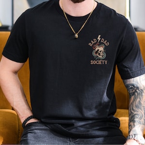 May include: Black t-shirt with a graphic of a skull with a snake wrapped around it. The graphic says "Rad Dad Society" above the skull.