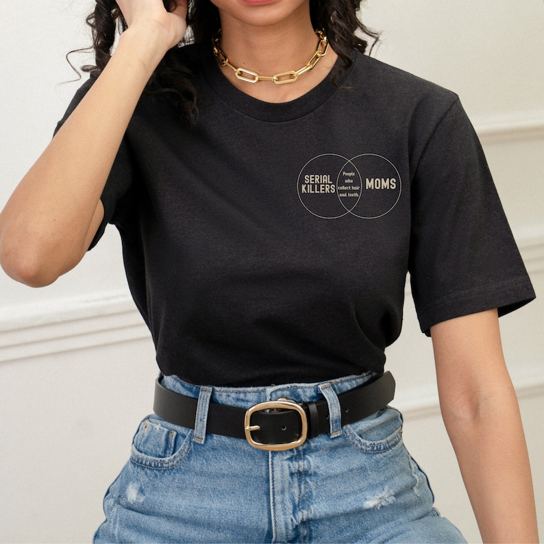 Puede incluir: Camiseta negra con un gr&aacute;fico de un diagrama de Venn que dice "Asesinos en serie" y "Mam&aacute;s". El texto en la secci&oacute;n superpuesta dice "Personas que coleccionan cabello y dientes."