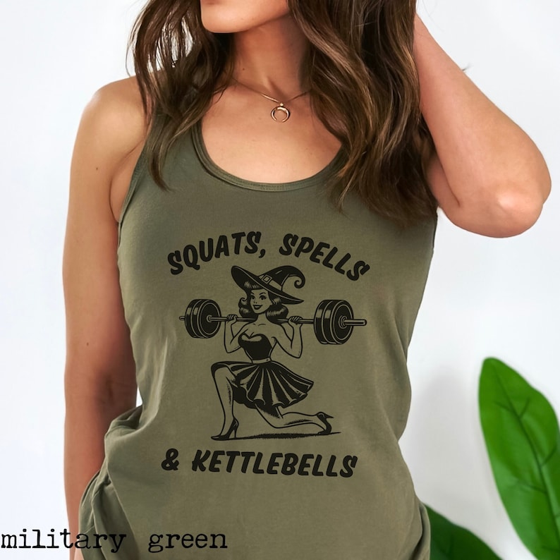 May include: A green tank top with a black graphic of a witch lifting a barbell. The text on the tank top reads "Squats, Spells & Kettlebells".