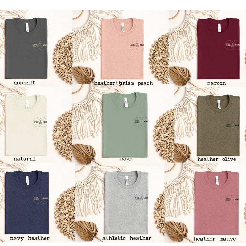 Puede incluir: Un conjunto de diez camisetas de diferentes colores, incluyendo asfalto, melocot&oacute;n de prisma de color, granate, natural, salvia, oliva jaspeado, azul marino jaspeado, jaspeado atl&eacute;tico y malva jaspeado. Cada camiseta presenta un dise&ntilde;o gr&aacute;fico simple con el texto "Soul Sisters" y "Mom" en un c&iacute;rculo.