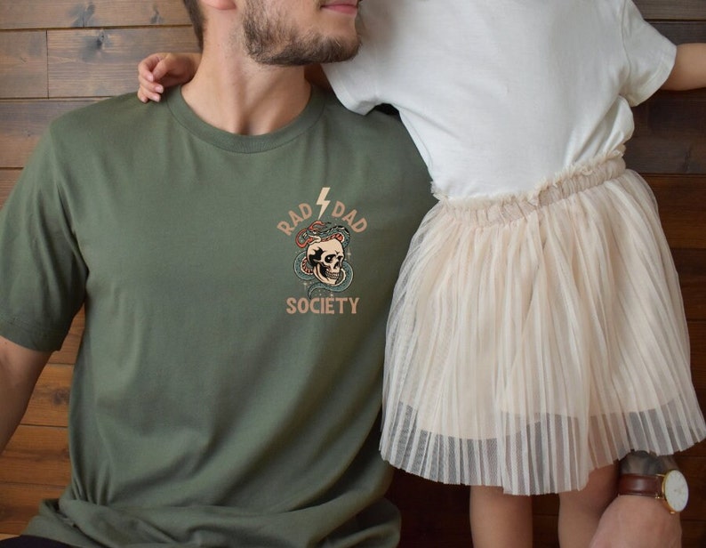 May include: A green t-shirt with a skull and snake graphic and the text "Rad Dad Society".
