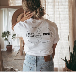 Puede incluir: Camiseta blanca con un gr&aacute;fico de diagrama de Venn que dice "Asesinos en serie" y "Mam&aacute;s" con la secci&oacute;n superpuesta que dice "Personas que recogen cabello y dientes."