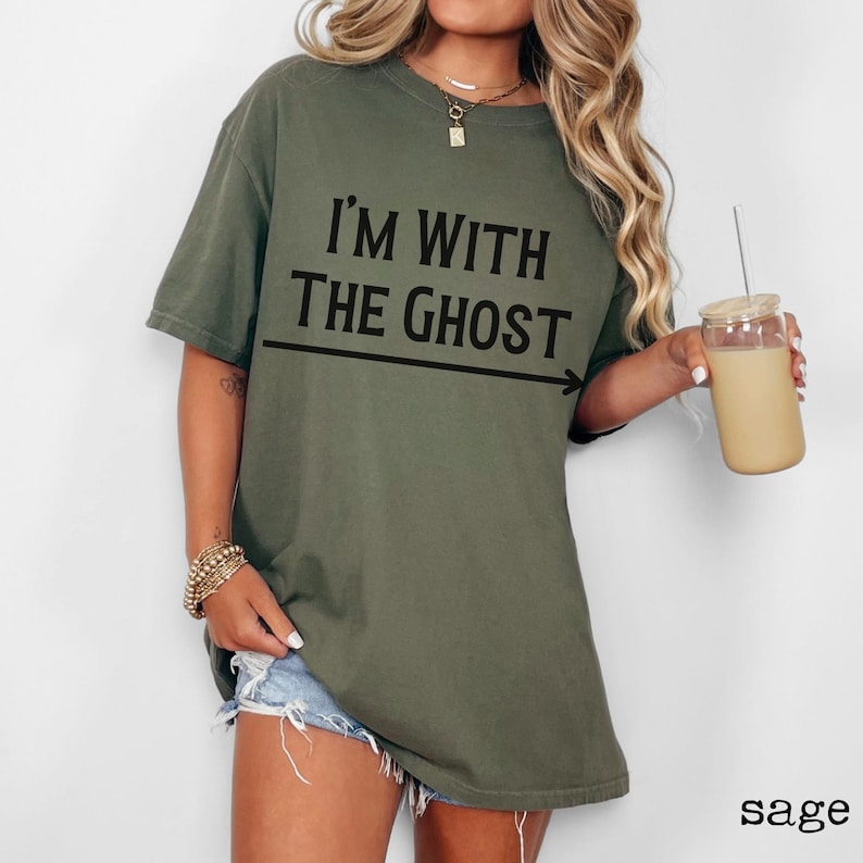 May include: Sage green oversized t-shirt with the text "I'm with the ghost" and an arrow pointing to the right.
