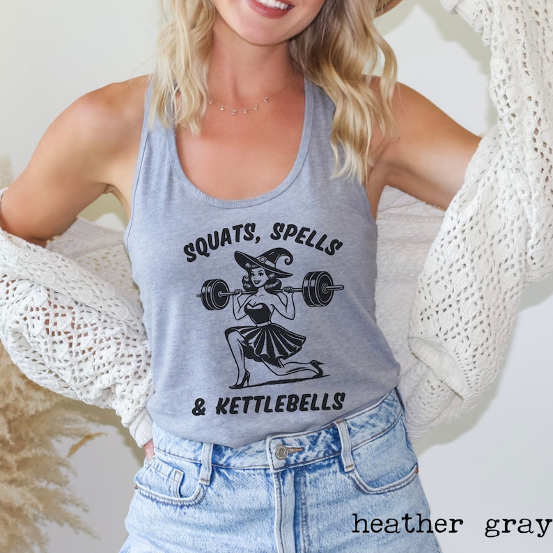 May include: Heather gray tank top with a black graphic of a witch lifting a barbell. The graphic says "SQUATS, SPELLS & KETTLEBELLS".