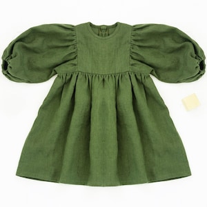 May include: A green linen dress with puffed sleeves and a gathered skirt.