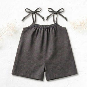 Op de afbeelding: Antracietgrijze romper met strikbandjes. De romper heeft een geplooid decolleté en een korte broek-stijl. De bandjes zijn in strikken op de schouders geknoopt. Het kledingstuk is gemaakt van een zachte, getextureerde stof.