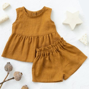 Set di modelli di cucito per top tunica senza maniche con volant e pantaloncini per bambini dalla nascita ai 6 anni.