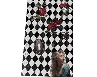 May include: A decorative planner insert featuring a black and white diamond pattern, red roses, a key, and a keyhole. A young woman with blonde hair and a blue dress is also featured in the design. The insert has several pre-punched holes.