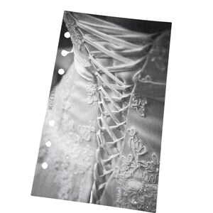 Puede incluir: Un vestido de novia blanco con un corpi&ntilde;o de encaje y una espalda de estilo cors&eacute; con cintas de sat&eacute;n blancas.