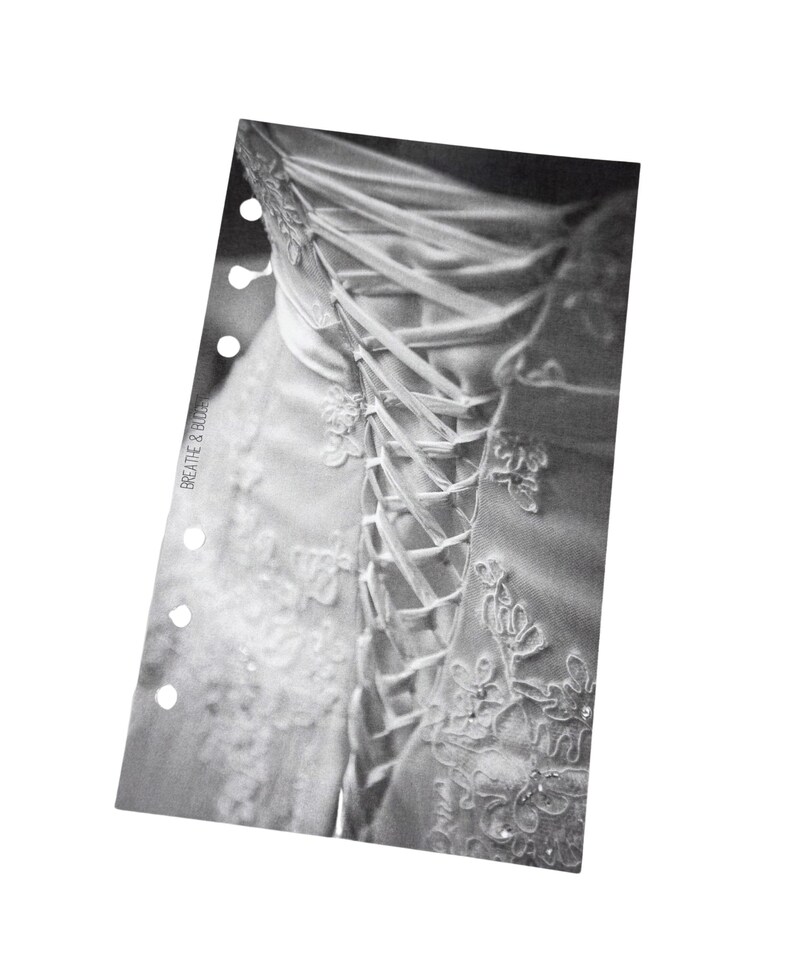 Puede incluir: Un vestido de novia blanco con un corpi&ntilde;o de encaje y una espalda de estilo cors&eacute; con cintas de sat&eacute;n blancas.