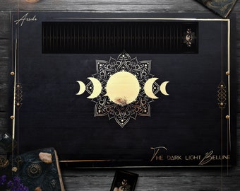May include: A black and gold tarot card deck box with a mandala design and the text "The Dark Light Bell Line" on the front.