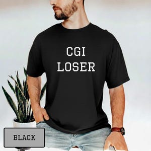 Pode incluir: Camiseta preta com o texto branco "CGI LOSER". A palavra "BLACK" é exibida em um retângulo cinza no canto inferior esquerdo da imagem. A camiseta é de estilo casual.