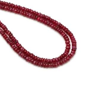 Peut inclure: Un collier à double rang de perles de rubis rouges. Les perles sont rondes et ont une forme légèrement irrégulière.