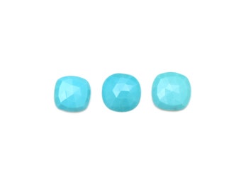 May include: Three turquoise blue gemstone cabochons, each with a faceted, cushion-shaped cut.