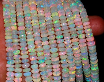 May include: A strand of white opal beads with iridescent rainbow colors. The beads are faceted and have a slightly oval shape.