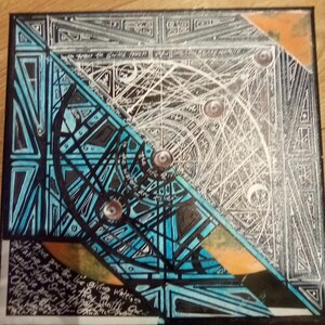 May include: Abstract geometric painting on canvas with black, white, blue, and orange colours. The painting features a central circle with three smaller circles inside. The background is a black and white geometric pattern.