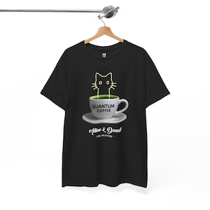 May include: Black t-shirt featuring a graphic of a cat head emerging from a coffee cup. The cup is labeled "QUANTUM COFFEE" and sits on a saucer. Below the cup, the text reads "Alive & Dead - Like My Energy".