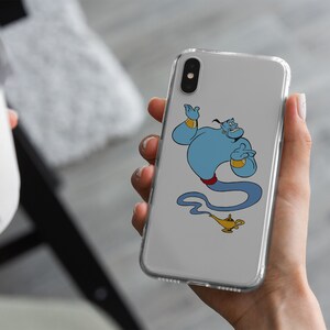 May include: A clear phone case with a cartoon image of Genie from Disney's Aladdin. Genie is blue with a red sash and is holding a lamp.