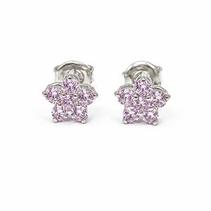 Può includere: Un paio di orecchini a lobo con un design a forma di fiore. Ogni orecchino è realizzato in metallo color argento e presenta cinque pietre rotonde sfaccettate rosa chiaro disposte a petalo attorno a una pietra centrale dello stesso colore.