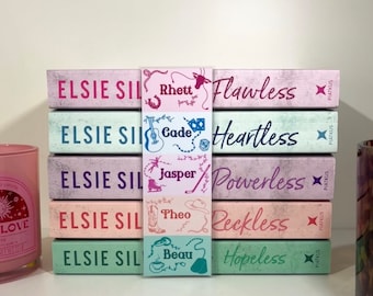 May include: A stack of five pink and green paperback books with a bookmark featuring different names and illustrations. The book titles are "Flawless", "Heartless", "Powerless", "Reckless", and "Hopeless".
