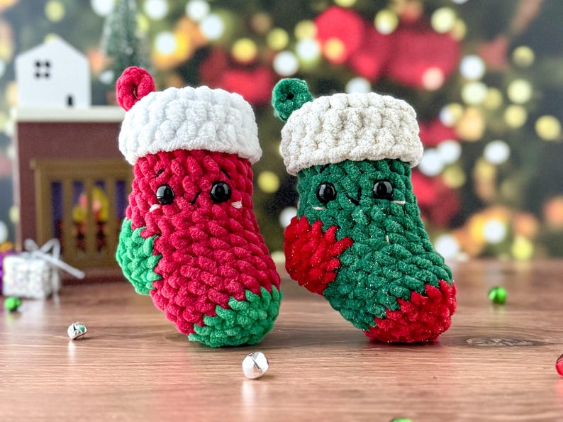 K&ouml;nnte beinhalten: Zwei handgefertigte Weihnachtsstrumpf-Ornamente. Eines ist rot mit gr&uuml;nen Akzenten, das andere ist gr&uuml;n mit roten Akzenten. Beide haben wei&szlig;e Verzierungen und kleine schwarze Augen. Diese Pl&uuml;schdekorationen sind perfekt.